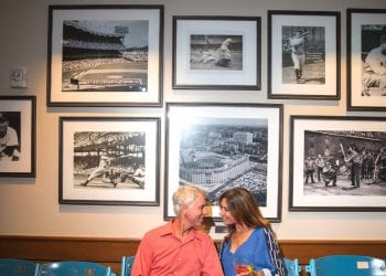 Couple seated on old Shea Stadium baseball seats at Grand Central at Boca West