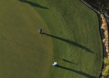 Two members play on an expansive green at Boca West