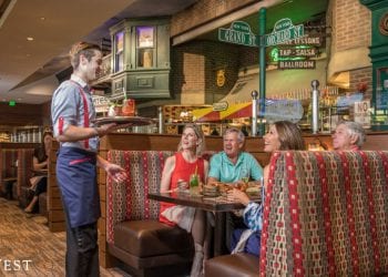 Friends at Boca West restaurant having a conversation with the waiter and laughing